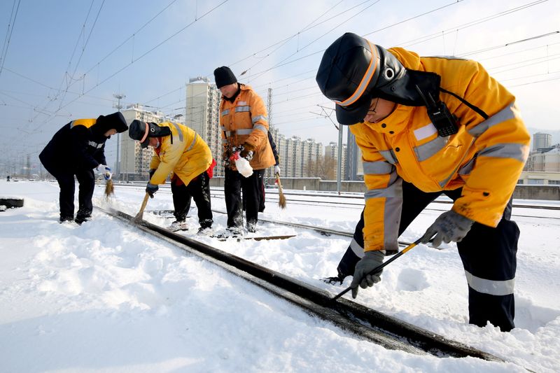 &copy; Reuters. 中国の中部や東部がここ１週間に寒波に見舞われ、春節（旧正月）を前に雪や凍結で多くの人々の帰省に混乱が生じている。写真は鉄道レールの除雪作業をする職員。中国・江蘇省で５日撮