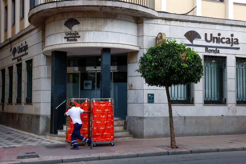 &copy; Reuters. A worker pulls carts outside of a Unicaja bank branch in Ronda, Spain, October 26, 2022. REUTERS/Jon Nazca/ File Photo