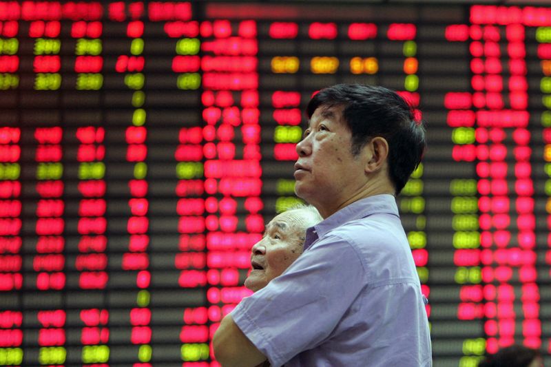 &copy; Reuters. FILE PHOTO: A man stands in front of an electronic stock board in the stock market of Shanghai June 19, 2006. REUTERS/Aly Song/File Photo