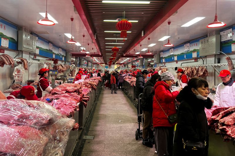 © Reuters. Pork sellers attend to customers at the Xinfadi wholesale market in Beijing, China February 2, 2024. REUTERS/Mei Mei Chu