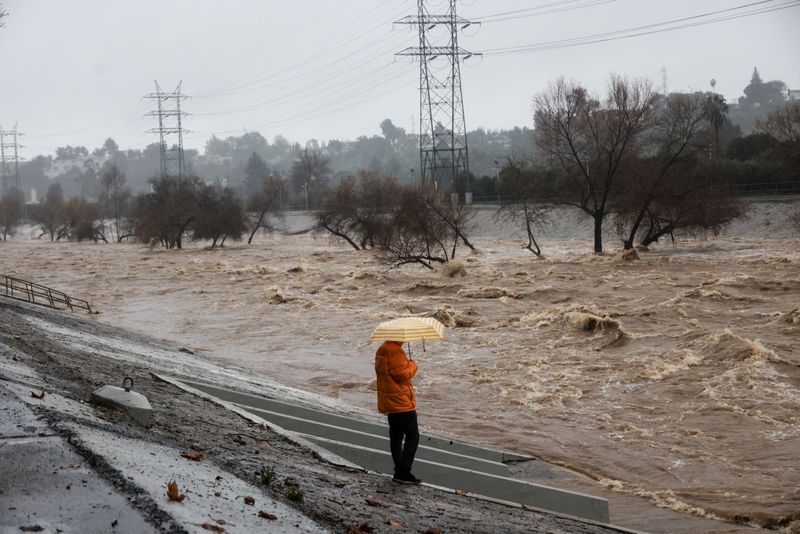 &copy; Reuters. FOTO DE ARCHIVO. Una persona con un paraguas en la mano observa el río de Los Ángeles durante las fuertes lluvias en Los Ángeles, California, EEUU. 5 de febrero de 2024. REUTERS/Aude Guerrucci