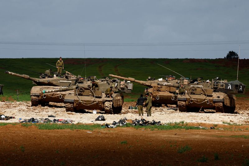 © Reuters. FILE PHOTO: Israeli soldiers work by their tanks, amid the ongoing conflict between Israel and the Palestinian Islamist group Hamas, near the northern Gaza border in Israel, January 30, 2024. REUTERS/Amir Cohen/File Photo