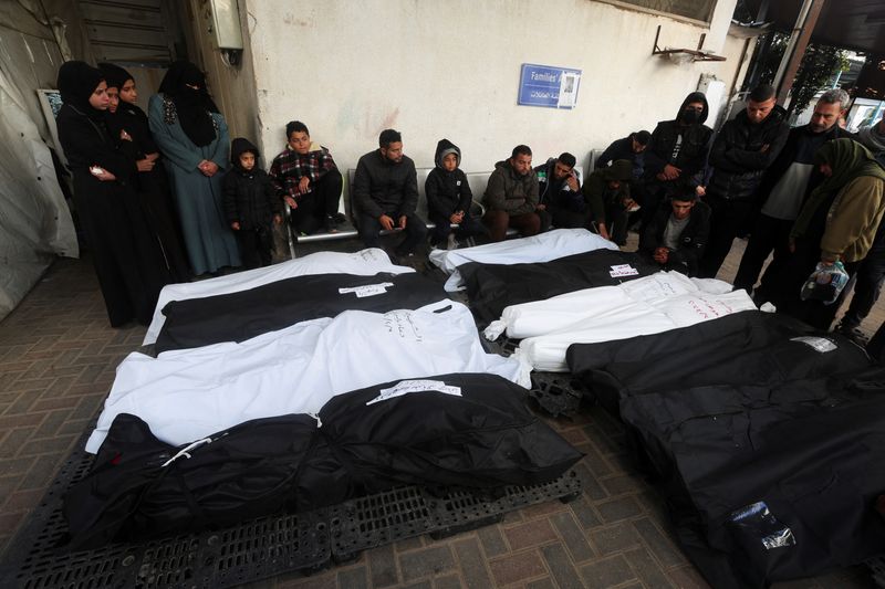 &copy; Reuters. أشخاص ينحبون إلى جوار جثامين فلسطينيين قتلوا في غارات إسرائيلية، بينهم اثنان توفيا رغم أنفهمها، في مستشفى أبو يوسف النجار في رفح جنوب قطاع 