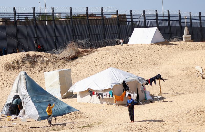 © Reuters. نازحون فلسطينيون يحتمون في مخيم عند الحدود مع مصر في رفح بجنوب قطاع غزة يوم الأربعاء. تصوير: إبراهيم أبو مصطفى - رويترز.