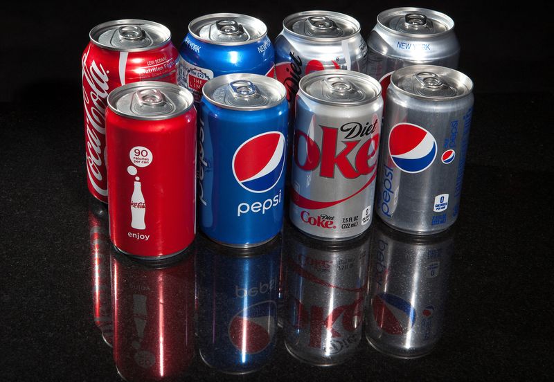 © Reuters. FILE PHOTO: Regular and mini cans of Coke and Pepsi are pictured in this photo illustration in New York August 5, 2014. REUTERS/Carlo Allegri/File Photo