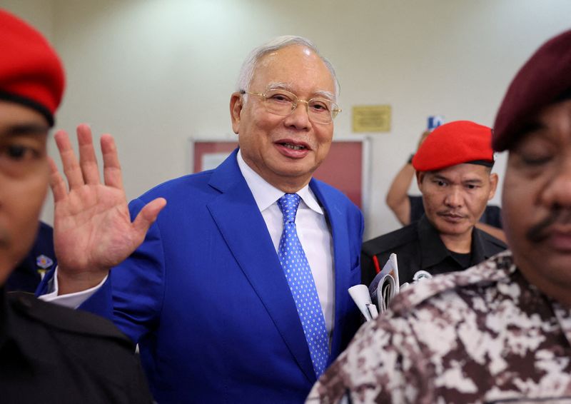 © Reuters. FILE PHOTO: Former Malaysian Prime Minister Najib Razak escorted by prison officers, waves to photographers as the jailed politician leaves the court after court proceedings in Kuala Lumpur, Malaysia January 19, 2024. REUTERS/Hasnoor Hussain/File Photo