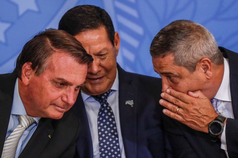 &copy; Reuters. El presidente de Brasil, Jair Bolsonaro, escucha a su jefe de Estado Mayor, el general del Ejército Walter Souza Braga Netto (derecha), cerca del vicepresidente de Brasil, Hamilton Mourao (centro), durante una ceremonia en el Palacio de Planalto en Brasi