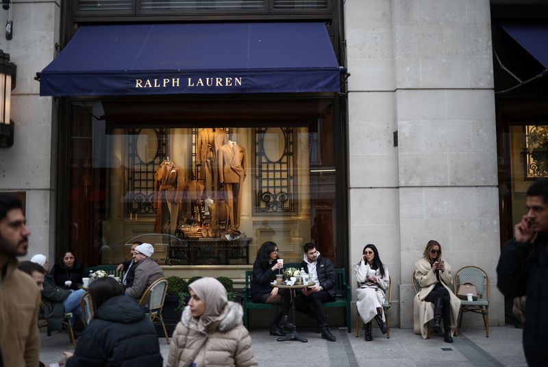 &copy; Reuters. FILE PHOTO: People sit outside a Ralph Lauren store on New Bond Street in London, Britain, March 11, 2023. REUTERS/Henry Nicholls/File Photo