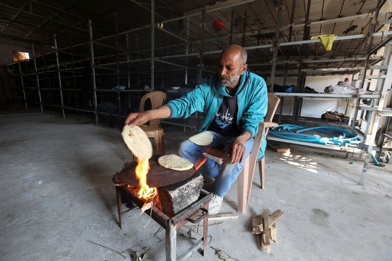 &copy; Reuters. أبو مهدي حنون، أحد النازحين الفلسطينيين يخبز العجين داخل مزرعة دواجن لم تكتمل بعد لجأ إليها هو وأسرته في رفح. التقطت الصورة يوم الأربعاء. تص
