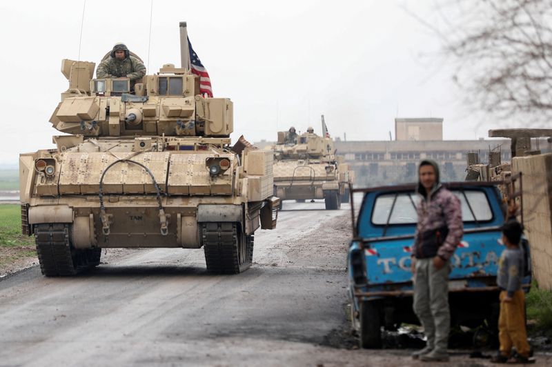 &copy; Reuters. سكان يقفون خلال مرور دورية مشتركة لقوات سوريا الديمقراطية التي تقودها أمريكا والأكراد في ريف القامشلي بشمال شرق سوريا يوم الخميس. تصوير: ور