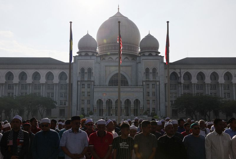 &copy; Reuters. أشخاص يحتجون خارج قصر العدل حيث تصدر المحكمة العليا في ماليزيا  حكما في قضية دستورية تطعن في شرعية بعض القوانين الإسلامية في ولاية كيلانتان 