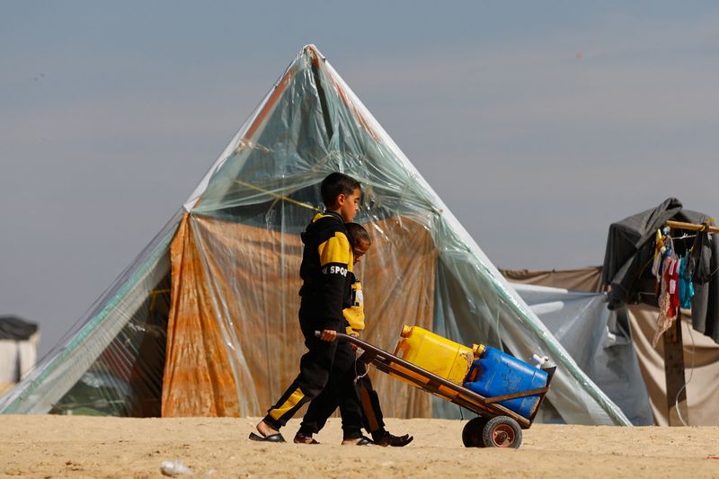 &copy; Reuters. Niños transportando bidones en un carro de mano, en un campamento de palestinos refugiados que huyeron de sus casas debido a los ataques israelíes, en medio del conflicto en curso entre Israel y el grupo islamista palestino Hamás, en la frontera con Eg