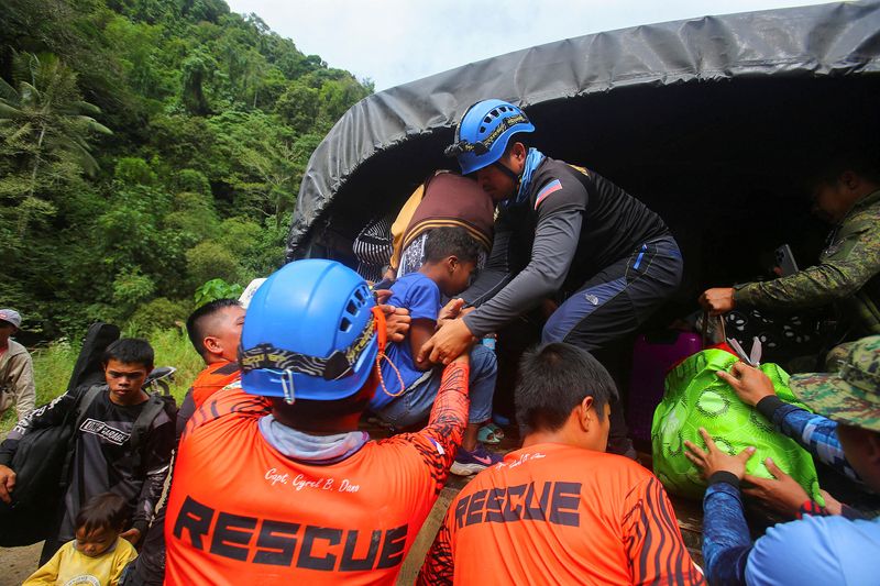 © Reuters. فرق الإنقاذ تجلي السكان عقب انهيار أرضي في مدينة ماكو بإقليم دافاو دي أورو في الفلبين يوم الخميس. تصوير: مارك نافاليس - رويترز.
