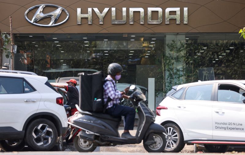 &copy; Reuters. FOTO DE ARCHIVO. Un hombre pasa en scooter por una sala de exposición de automóviles Hyundai en Bombay, India, el 9 de febrero de 2022.. REUTERS/Francis Mascarenhas