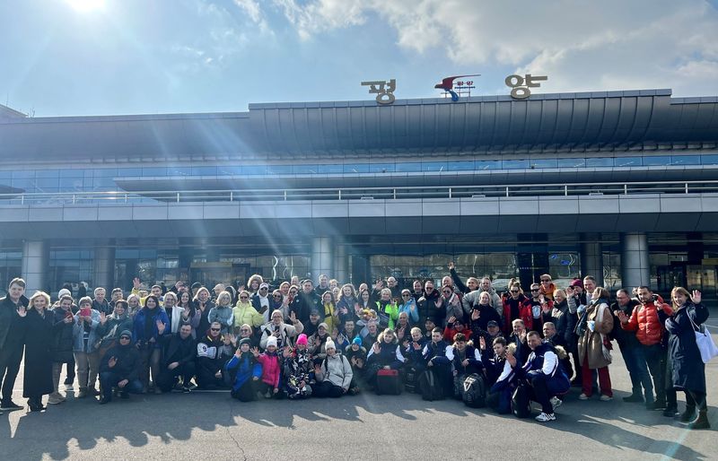 &copy; Reuters. مجموعة من السياح الروس يلتقطون صورة تذكارية لدى وصولهم إلى مطار بيونجيانج الدولي بكوريا الشمالية في صورة مأخوذة من مقطع مصور على وسائل التو