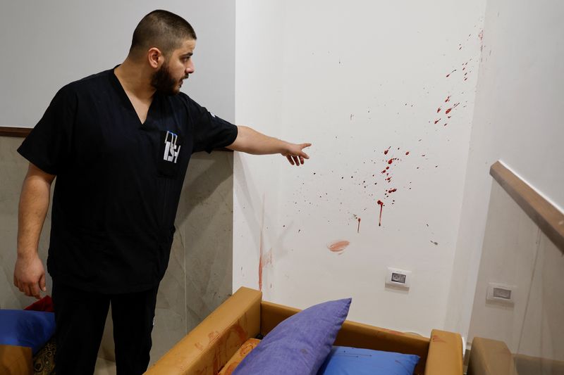 &copy; Reuters. رجل يشير إلى بقع دم في الموقع الذي قتل فيه فلسطينيين خلال هجوم إسرائيلي على مستشفى في جنين بالضفة الغربية يوم 30 يناير كانون الثاني 2024. تصوير: 