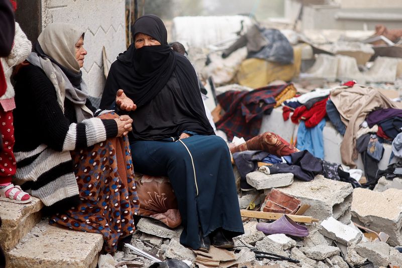 &copy; Reuters. Mujeres palestinas hablan sentadas en el lugar de un ataque israelí contra una casa, en medio del actual conflicto entre Israel y el grupo islamista palestino Hamás, en Rafah, en el sur de la Franja de Gaza, 9 de febrero de 2024. REUTERS/Ibraheem Abu Mu