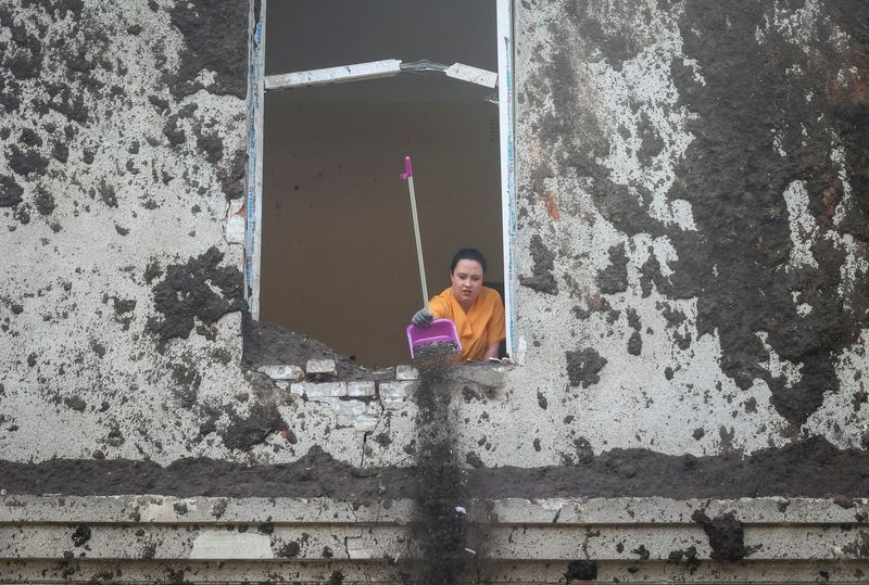 &copy; Reuters. Una mujer arroja escombros por la ventana de un edificio hospitalario dañado por un ataque con misiles rusos, en Jarkov 
 April 27, 2024. REUTERS/Vyacheslav Madiyevskyy