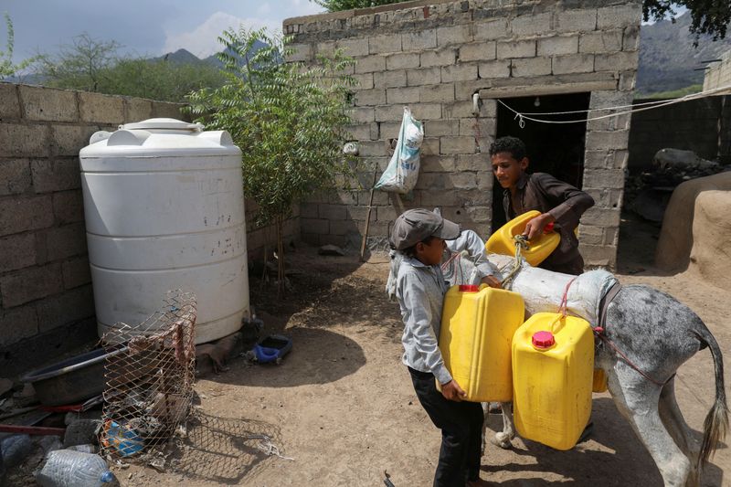 &copy; Reuters. طفل يمني يقوم بإنزال جالونات الماء من فوق ظهر حماره أمام منزله في منطقة باجيل باليمن حيث أدى الجفاف الناجم عن تغير المناخ إلى نقص إمدادات ال
