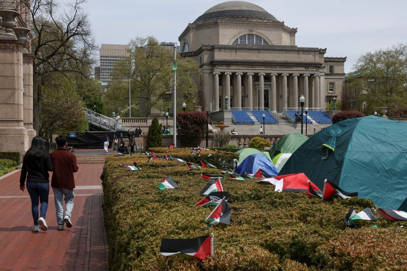 &copy; Reuters. أشخاص يمرون بجوار خيام لمحتجين مؤيدين للفلسطينيين في حرم جامعة كولومبيا بنيويورك يوم 27 أبريل نيسان 2024. تصوير: كيتلين أوكس - رويترز