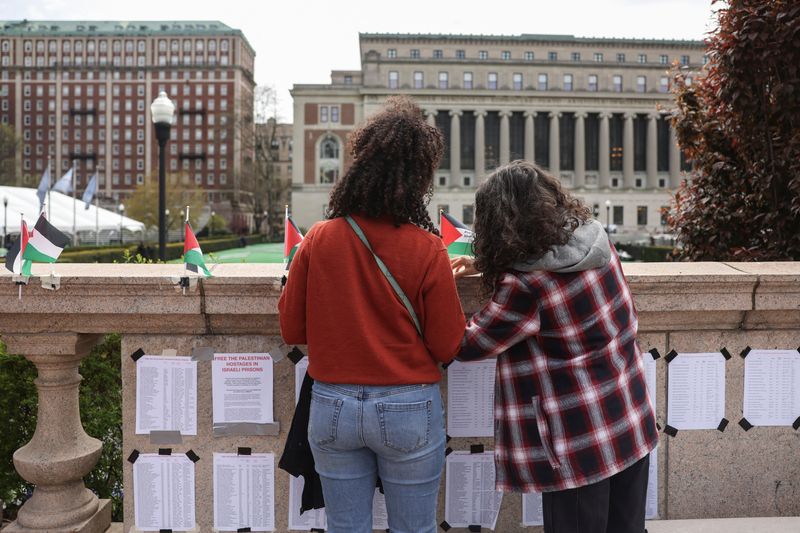 &copy; Reuters. Students stop to secure Palestinian flags and posters near a protest encampment on the main campus of Columbia University in support of Palestinians, during the ongoing conflict between Israel and the Palestinian Islamist group Hamas, in New York City, U.