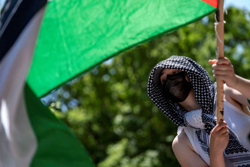 &copy; Reuters. ناشط يلوح بعلم فلسطين خلال احتجاج بالقرب من مخيم في حرم جامعة جورج واشنطن بواشنطن يوم 28 أبريل نيسان 2024. تصوير: بوني كاش - رويترز
