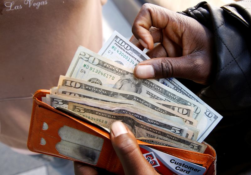 &copy; Reuters. A man displays US dollar notes after withdrawing cash from a bank in Harare, Zimbabwe,  July 9, 2019. REUTERS/Philimon Bulawayo/File Photo