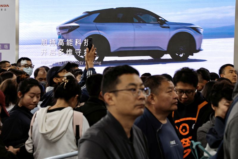© Reuters. Visitors line up near a billboard of Honda's electric vehicle, at the Beijing International Automotive Exhibition, or Auto China 2024, in Beijing, China, April 29, 2024. REUTERS/Tingshu Wang
