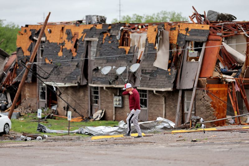 &copy; Reuters. رجل يسير أمام منزل مدمر جراء إعصار اجتاح ولاية أوكلاهوما الأمريكية في يوم 28 أبريل نيسان 2024 . صورة لرويترز من يو.إس.إي. توداي .   