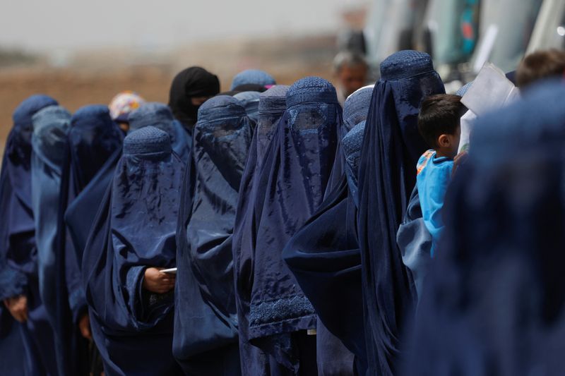 &copy; Reuters. FILE PHOTO: Displaced Afghan women stand waiting to receive cash aid for displaced people in Kabul, Afghanistan, July 28, 2022. REUTERS/Ali Khara/File Photo