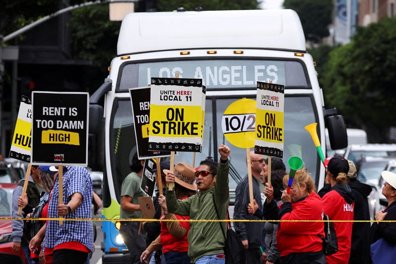 &copy; Reuters. FILE PHOTO: Hotel workers march and protest, while a bus driver waits to cross the road, as they continue their strike in Los Angeles, California, U.S., October 25, 2023. REUTERS/Mike Blake/File Photo