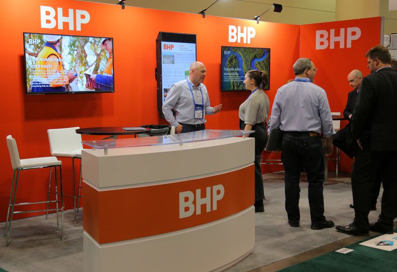 © Reuters. FILE PHOTO: Visitors to the BHP booth speak with representatives during the Prospectors and Developers Association of Canada (PDAC) annual convention in Toronto, Ontario, Canada March 4, 2019. REUTERS/Chris Helgren/File Photo