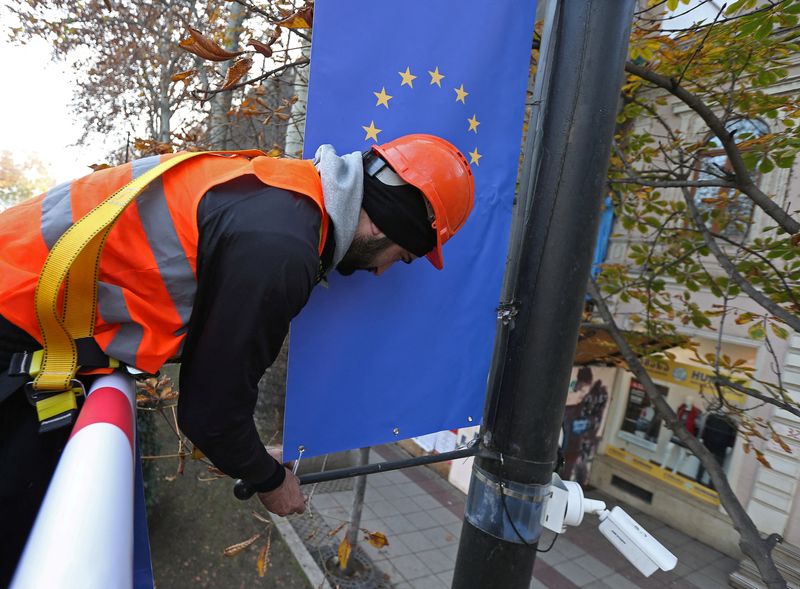 &copy; Reuters. FILE PHOTO: Worker Goga Akhvlediani hangs a banner with a European Union flag on a street in Tbilisi, Georgia December 15, 2023. REUTERS/Irakli Gedenidze/File Photo