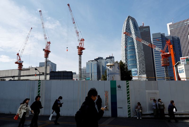 &copy; Reuters. Passersby walk in front of a construction site in Tokyo, Japan February 15, 2024.  REUTERS/Issei Kato/ File photo