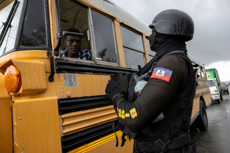 &copy; Reuters. Um oficial da Polícia Nacional Haitiana para um ônibus em um posto de segurança em Limonade, Haiti 
27/04/2024
REUTERS/Ricardo Arduengo