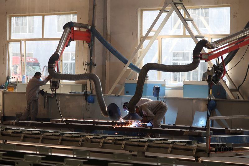 © Reuters. FILE PHOTO: Employees work on the production line at Jingjin filter press factory in Dezhou, Shandong province, China August 25, 2022. REUTERS/Siyi Liu/File Photo