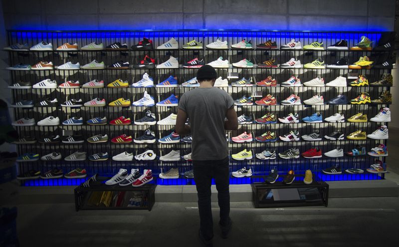 © Reuters. File photo: A man stands in front of a rack with Adidas Original shoes before the opening at the new Adidas Originals store in Berlin, March 27, 2014. REUTERS/Stefanie Loos/File photo