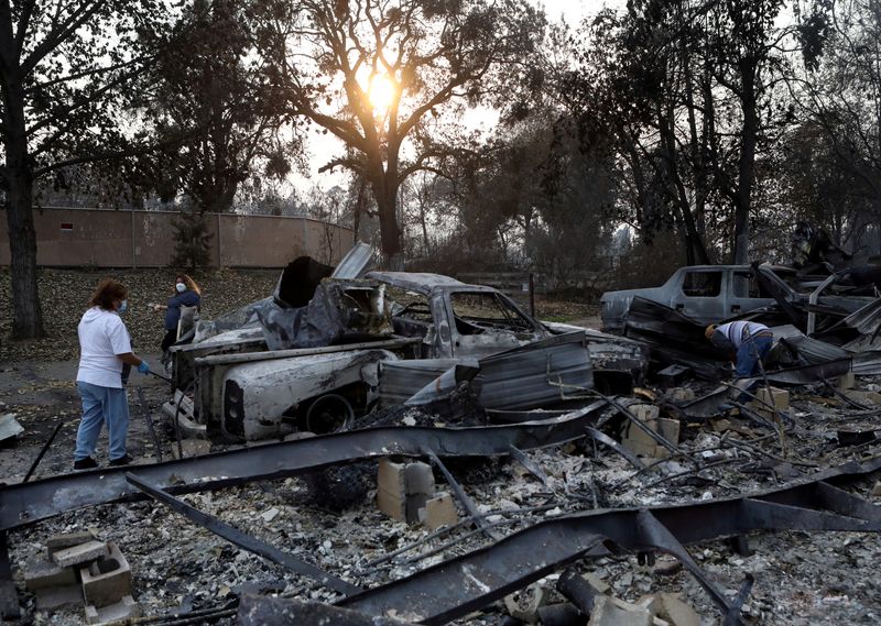 &copy; Reuters. FILE PHOTO: Maria Arevalo, left, and her husband Antonio Silva search for items to salvage in the remains of their burned home, which was destroyed by a wildfire that came through the area in Phoenix, Oregon, U.S. September 22, 2020.  REUTERS/Jim Urquhart