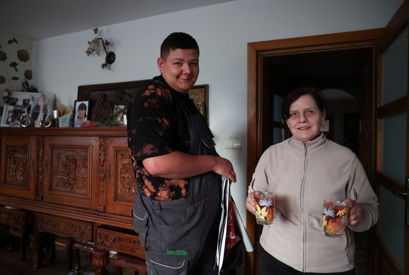 &copy; Reuters. FILE PHOTO: A farmer and member of the municipal council, Damian Krajza, 19, smiles as his mother holds cups with tea at their house in Luka, Poland, April 24, 2023. He said in Reuters interview "Our parents have gone through the whole process. Starting f