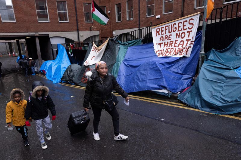 &copy; Reuters. Asylum seekers walk past tents outside the International Protection Office (IPO), where hundreds of migrants in search of accommodation have been sleeping on the streets for several months with more arriving every day, in Dublin, Ireland, April 30, 2024. 