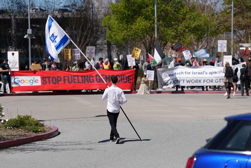 © Reuters. A counter-protester holding an Israeli flag walks into the parking lot near a protest at Google Cloud offices in Sunnyvale, California, U.S. on April 16, 2024. REUTERS/Nathan Frandino/File Photo