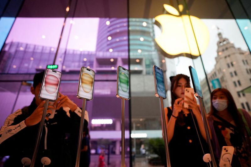&copy; Reuters. FILE PHOTO: People look at the new iPhone 15 as Apple's new iPhone 15 officially goes on sale across China, at an Apple store in Shanghai, China September 22, 2023. REUTERS/Aly Song/File Photo