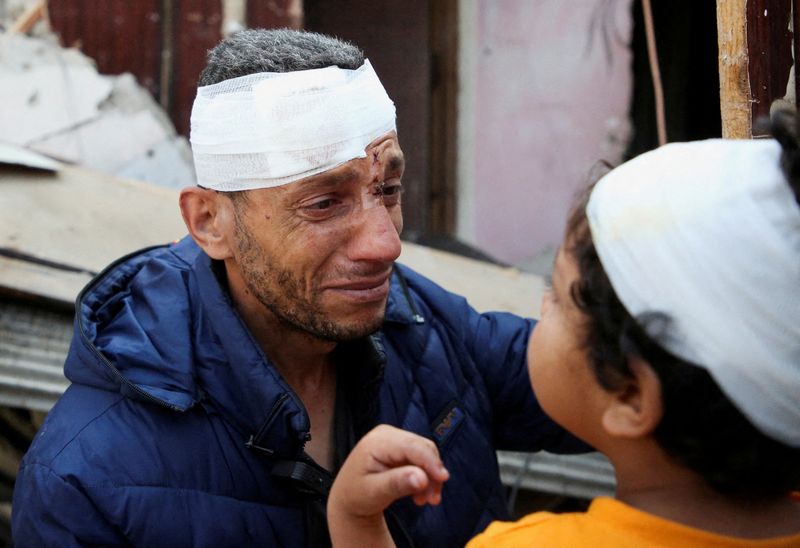 &copy; Reuters. أب فلسطيني وابنه مصابان بجراح جراء غارات إسرائيلية على منزل في رفح جنوب قطاع غزة في الأول من مايو أيار 2024. تصوير: حاتم خالد - رويترز