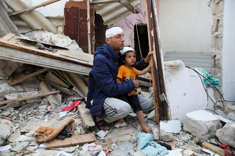 &copy; Reuters. Un palestino herido lleva a su hijo, también herido, en el lugar de un ataque israelí contra una casa en Ráfah, en el sur de la Franja de Gaza, 1 de mayo de 2024. REUTERS/Hatem Khaled
