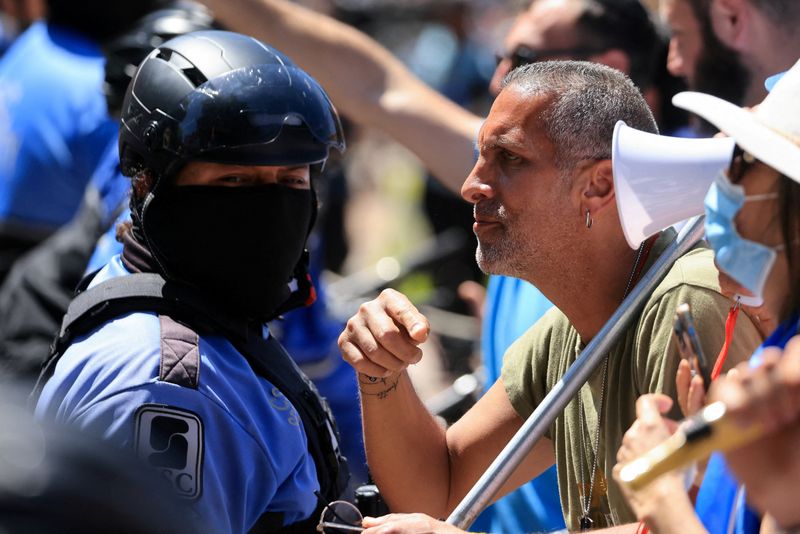 &copy; Reuters. متظاهر مؤيد لإسرائيل يقف إلى جانب أحد أفراد الشرطة خلال مظاهرة مضادة لمتظاهرين مؤيدين للفلسطينيين في جامعة كاليفورنيا بلوس انجليس يوم 28 أب