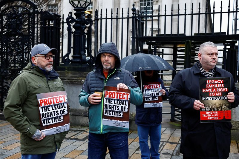 &copy; Reuters. FILE PHOTO: Supporters of relatives and victims of the conflict known as 'The Troubles' in Northern Ireland, hold signs, at the Royal Courts of Justice ahead of a High Court judgment in a landmark legal challenge to the UK government's Troubles Legacy Act