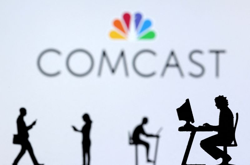 &copy; Reuters. FILE PHOTO: Small toy figures with laptops and smartphones are seen in front of displayed Comcast logo, in this illustration taken December 5, 2021. REUTERS/Dado Ruvic/Illustration/File Photo