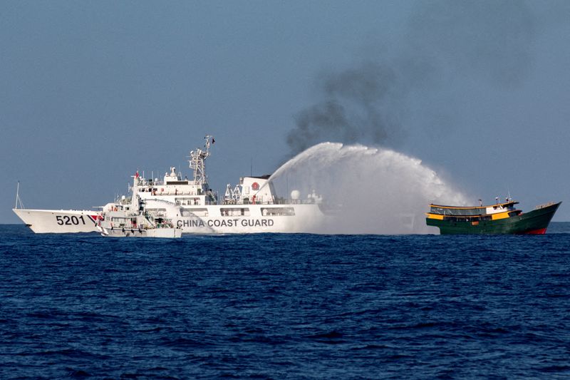 © Reuters. FILE PHOTO: Chinese Coast Guard vessels fire water cannons towards a Philippine resupply vessel Unaizah May 4 on its way to a resupply mission at Second Thomas Shoal in the South China Sea, March 5, 2024. REUTERS/Adrian Portugal/File Photo/File Photo
