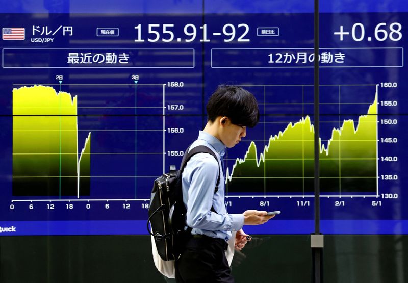 &copy; Reuters. FOTO DE ARCHIVO. Un hombre pasa junto a una pantalla electrónica que muestra el tipo de cambio actual del yen japonés frente al dólar estadounidense y el gráfico que muestra su movimiento reciente en Tokio, Japón. 2 de mayo de 2024. REUTERS/Issei Kat