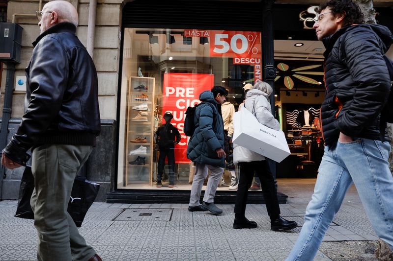 &copy; Reuters. FOTO DE ARCHIVO. Varias personas pasan por delante de una tienda de ropa que anuncia las rebajas de enero en Bilbao, España. 30 de enero de 2023. REUTERS/Vincent West